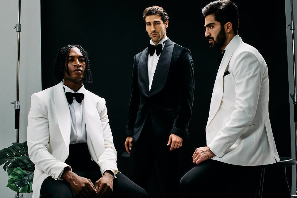 Men in white dinner jackets and a black tuxedo for a tuxedo vs suit formalwear guide